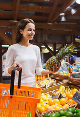 Image showing happy young woman with food basket in market