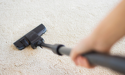 Image showing close up of hand with vacuum cleaner at home