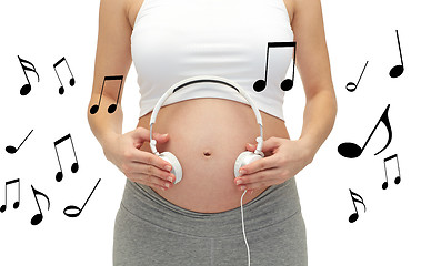 Image showing close up of pregnant woman and headphones on tummy