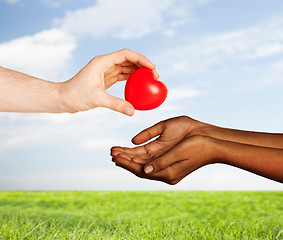 Image showing woman and man hands with red heart