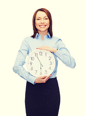 Image showing attractive businesswoman with wall clock