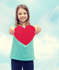 Image showing smiling little girl giving red heart