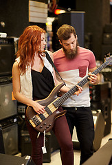 Image showing musicians playing bass guitar at music store