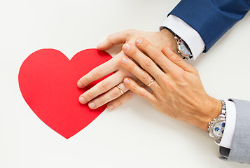 Image showing close up of male gay couple hands with red heart