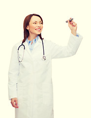 Image showing young female doctor writing something in the air