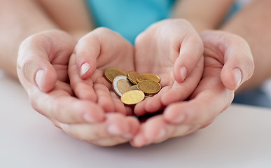 Image showing close up of family hands holding euro money coins