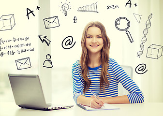 Image showing smiling teenage girl laptop computer and notebook