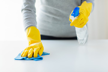 Image showing close up of woman cleaning table with cloth