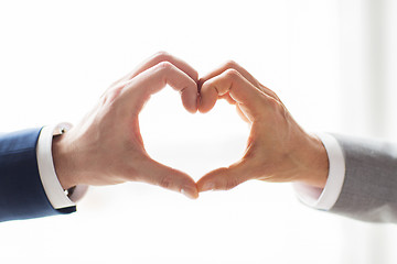 Image showing close up of male gay couple hands showing heart