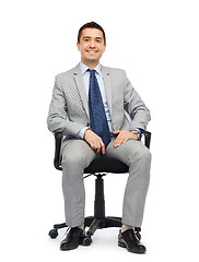 Image showing happy businessman  sitting in office chair