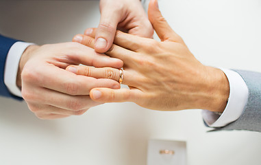 Image showing close up of male gay couple hands and wedding ring