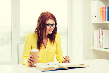 Image showing smiling student girl reading books in library