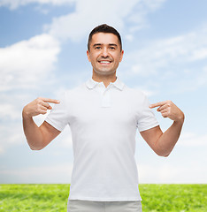 Image showing smiling man in t-shirt pointing fingers on himself