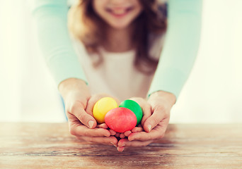 Image showing close up of girl and mother holding colored eggs