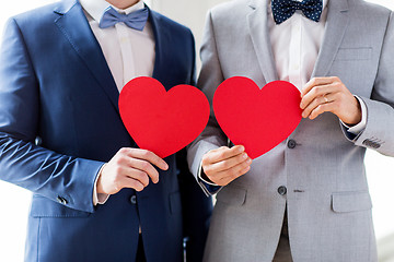 Image showing close up of male gay couple holding red hearts