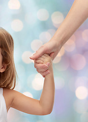 Image showing close up of woman and little girl holding hands