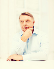 Image showing stressed old man holding head at home