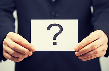 Image showing man in suit holding card with question mark