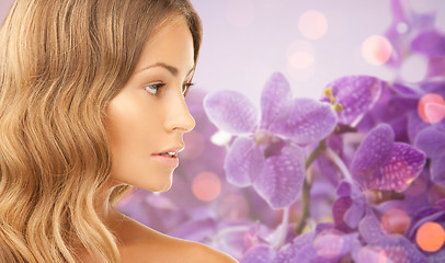 Image showing beautiful young woman face over orchid background