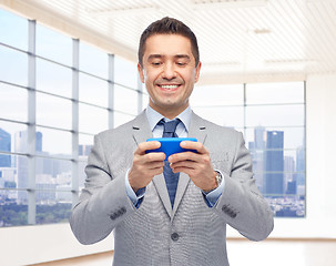 Image showing happy businessman texting on smartphone