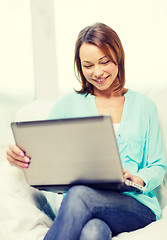 Image showing smiling woman with laptop computer at home