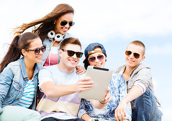 Image showing group of teenagers looking at tablet pc