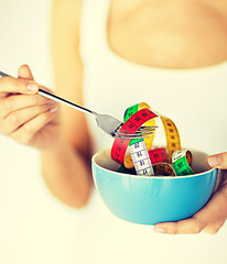 Image showing woman hands holding bowl with measuring tape