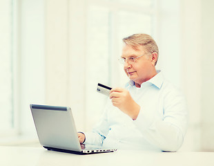 Image showing old man with laptop and credit card at home