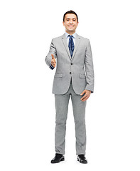 Image showing happy smiling businessman in suit shaking hand