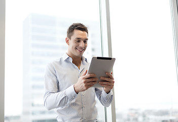 Image showing smiling businessman with tablet pc in office