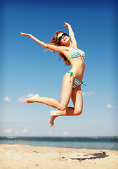 Image showing woman in bikini jumping on the beach