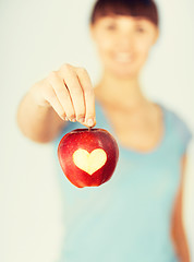 Image showing woman hand holding red apple with heart shape