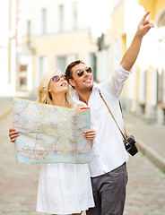 Image showing smiling couple in sunglasses with map in the city