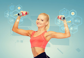 Image showing smiling beautiful sporty woman with dumbbells