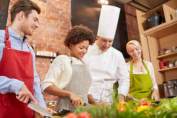 Image showing happy friends and chef cook cooking in kitchen