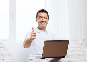 Image showing happy man working with laptop computer at home