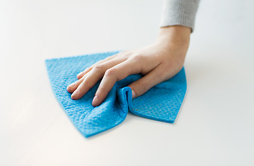 Image showing close up of hand cleaning table surface with cloth