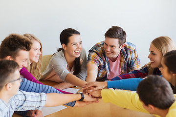 Image showing group of smiling students with hand on top