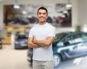 Image showing smiling man in white t-shirt over  auto salon