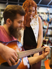 Image showing couple of musicians with guitar at music store