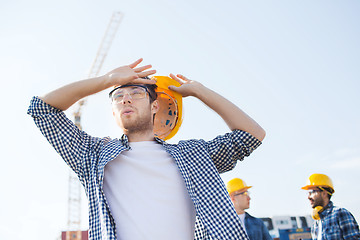 Image showing group of builders in hardhats outdoors