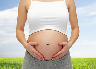 Image showing close up of pregnant woman touching her bare tummy