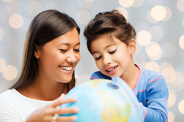 Image showing happy mother and daughter with globe