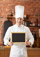 Image showing happy male chef with blank menu board in kitchen