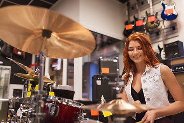 Image showing smiling musician playing cymbals at music store