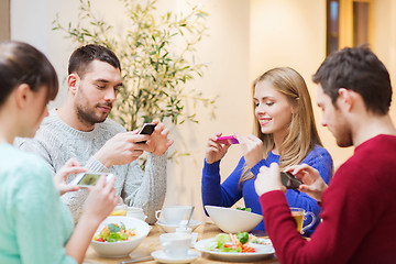 Image showing friends with smartphones taking picture of food