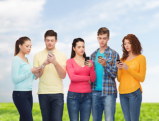 Image showing group of serious teenagers with smartphones