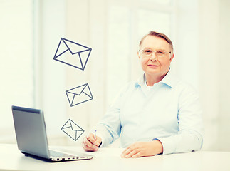 Image showing old man in eyeglasses filling a form at home