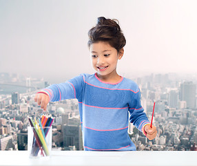 Image showing happy little girl drawing with coloring pencils