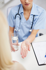 Image showing close up of doctor giving pills to patient